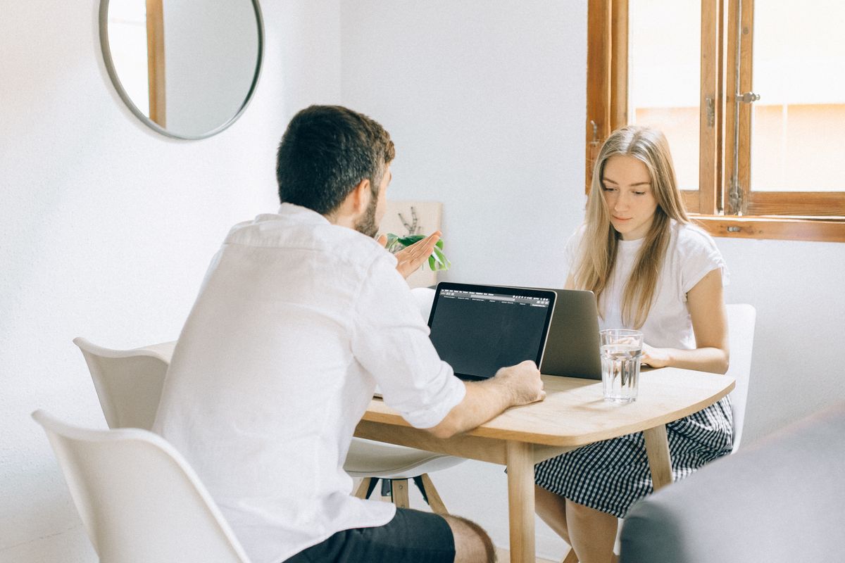 Two colleagues going through work on a laptop